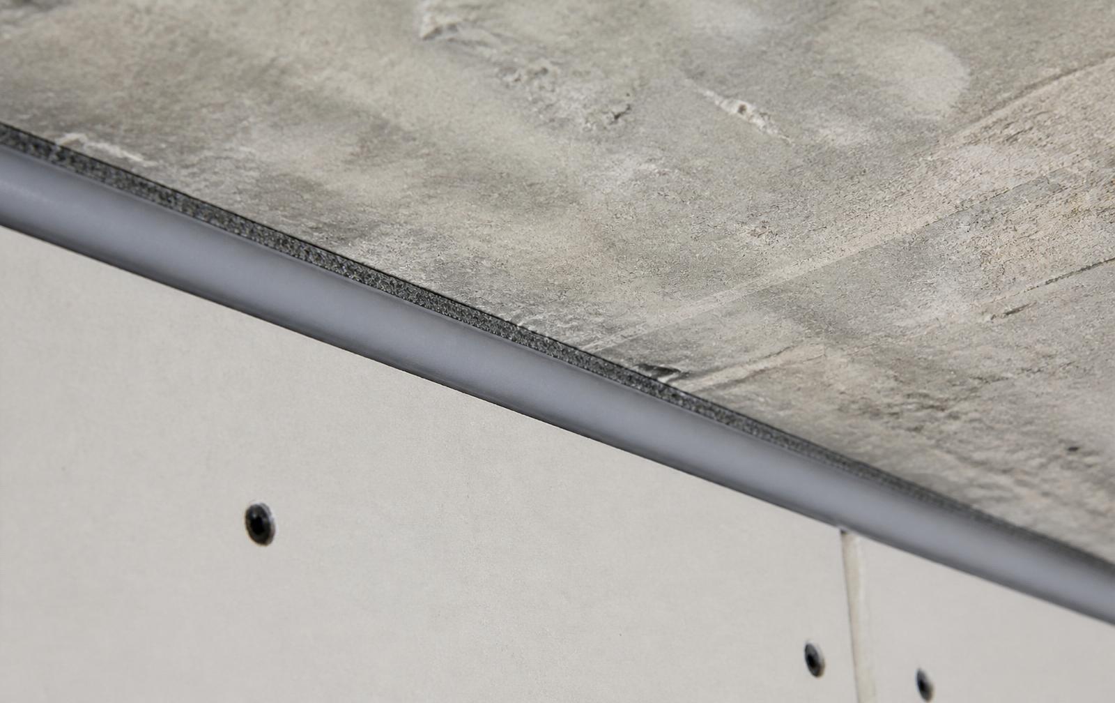 Linear gap fire sealing bead along a head-of-wall junction between plasterboard and concrete soffit